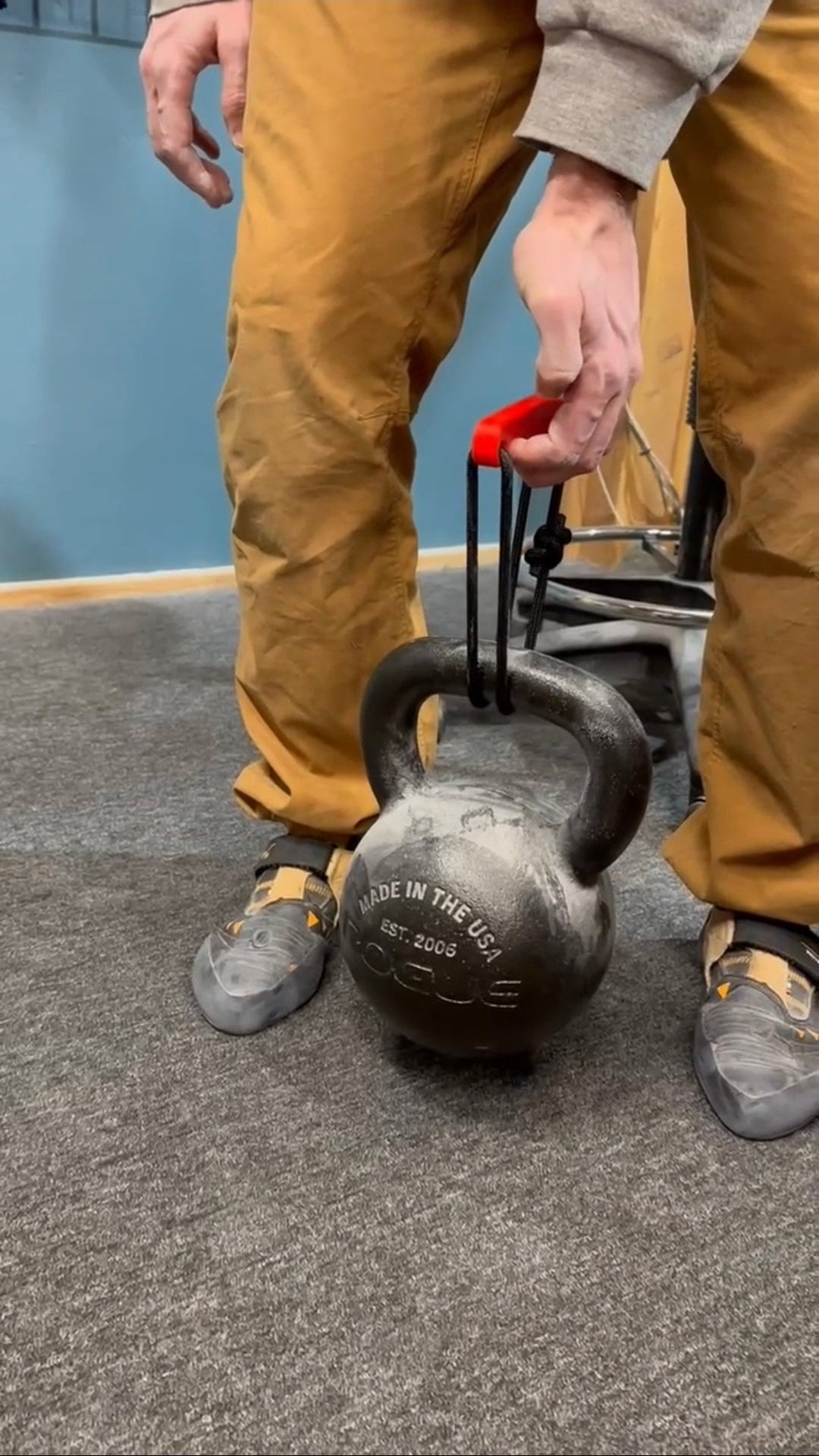 Person picking up kettlebell using Minimalist